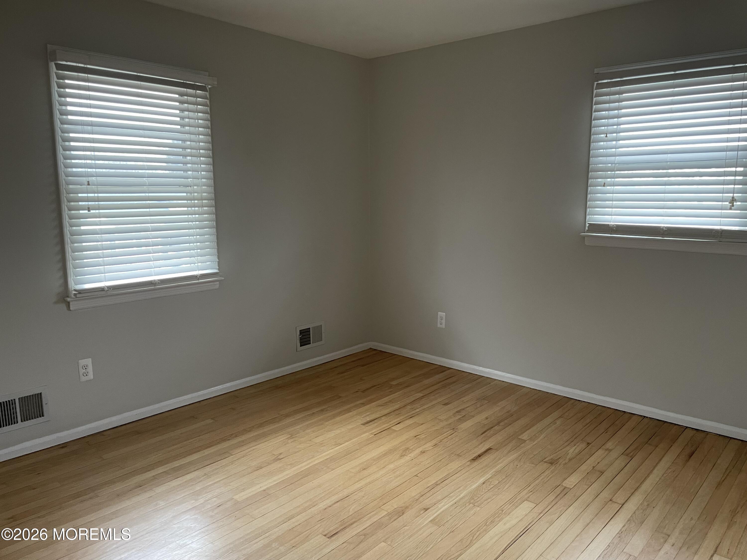 13 Johnson Avenue, Unit 2 Matawan, NJ 07747 - Photo 8 of 10 a view of an empty room with wooden floor and a window