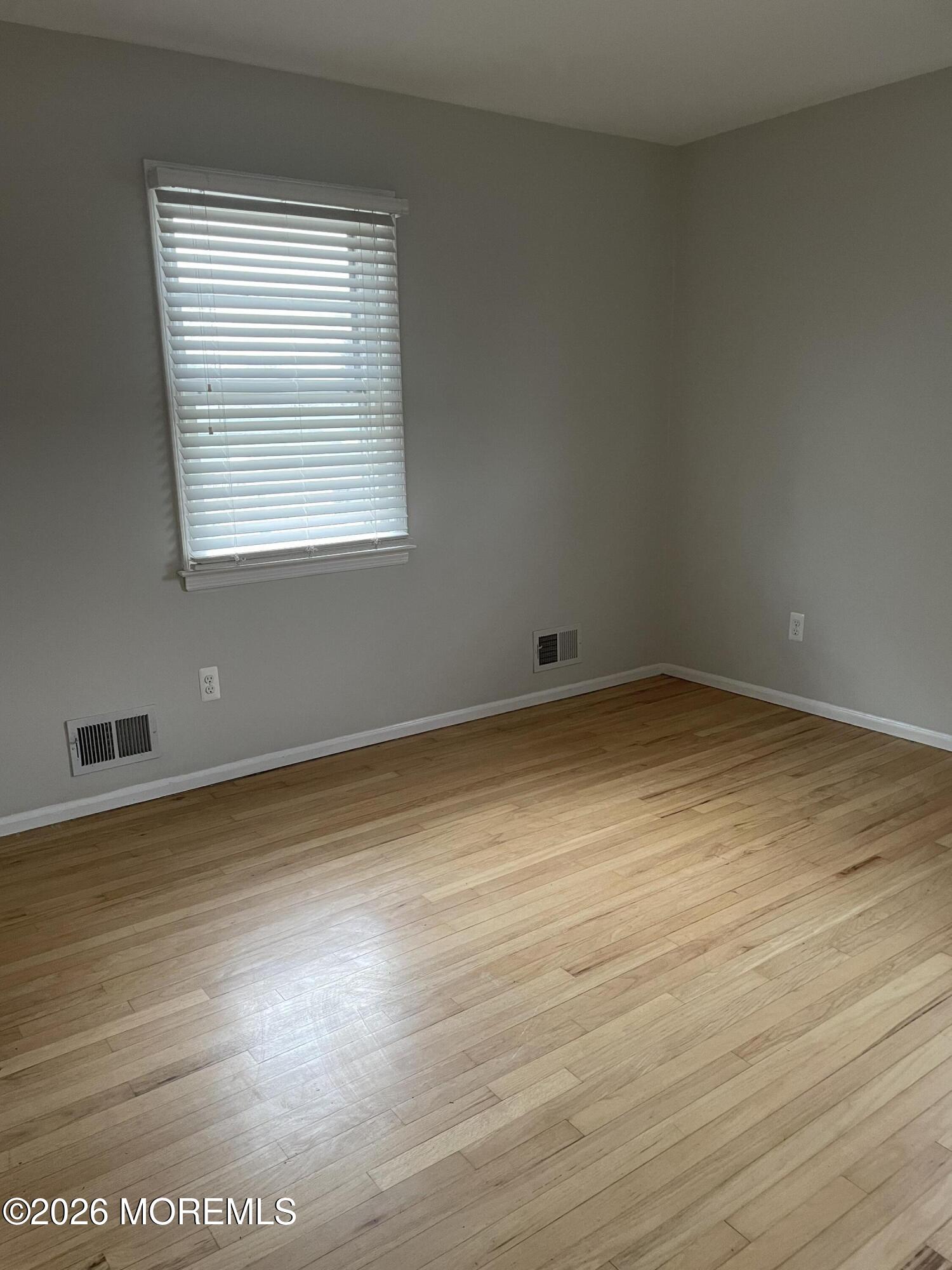 13 Johnson Avenue, Unit 2 Matawan, NJ 07747 - Photo 9 of 10 an empty room with wooden floor and windows