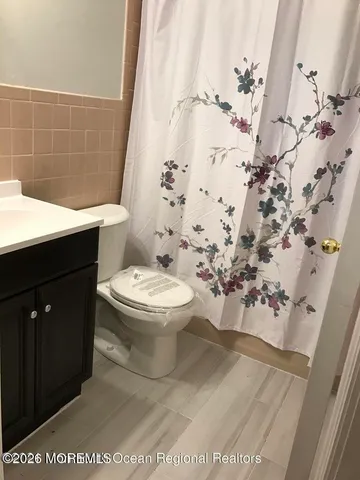 a bathroom with a toilet and a shower curtain