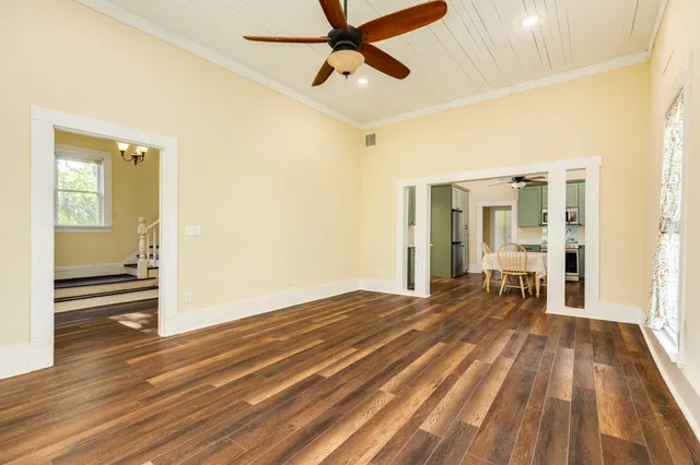 a view of a room with wooden floor and a ceiling fan