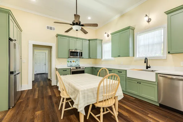 a kitchen with a table chairs sink and refrigerator