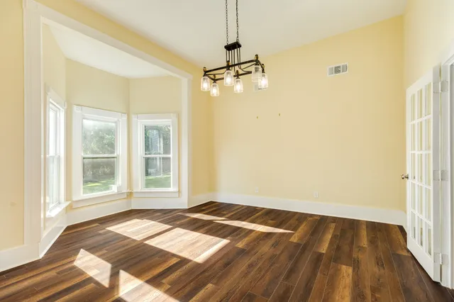 a view of a room with wooden floor and windows