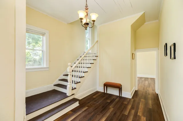 a view of a hallway with front door and wooden floor