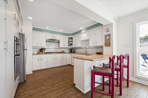 a kitchen with white cabinets and stainless steel appliances