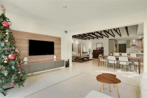 a living room with furniture a flowers and a flat screen tv