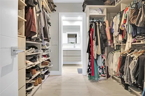 a view of walk in closet with clothes and shoes