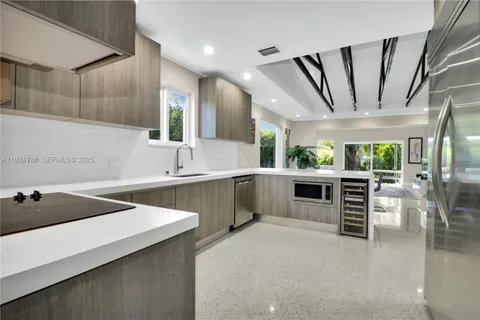a kitchen with stainless steel appliances a sink window and cabinets