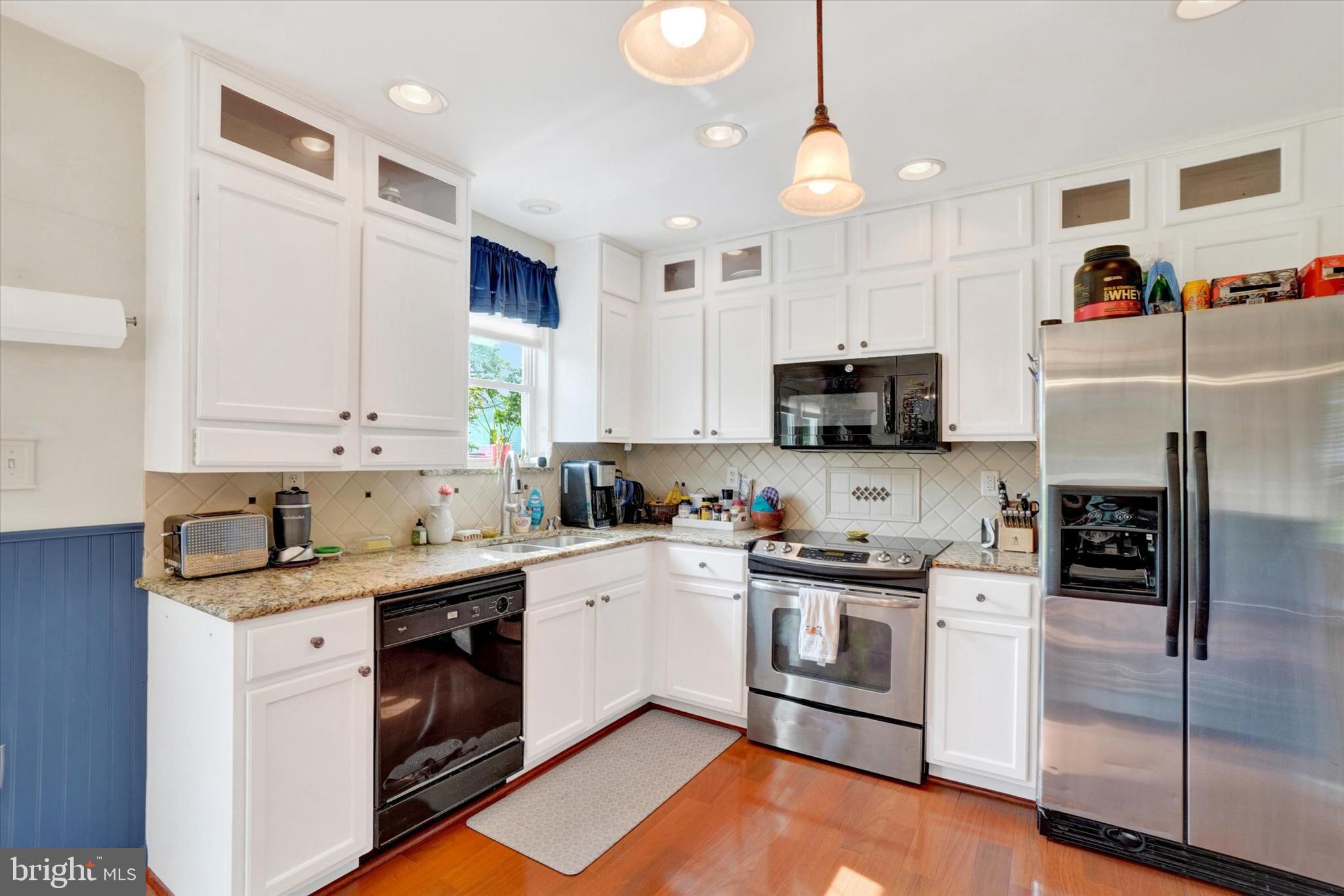 335 Sechrist Flat Road Felton, PA 17322 - Photo 8 of 28 a kitchen with stainless steel appliances white cabinets a sink a stove a microwave and wooden floors