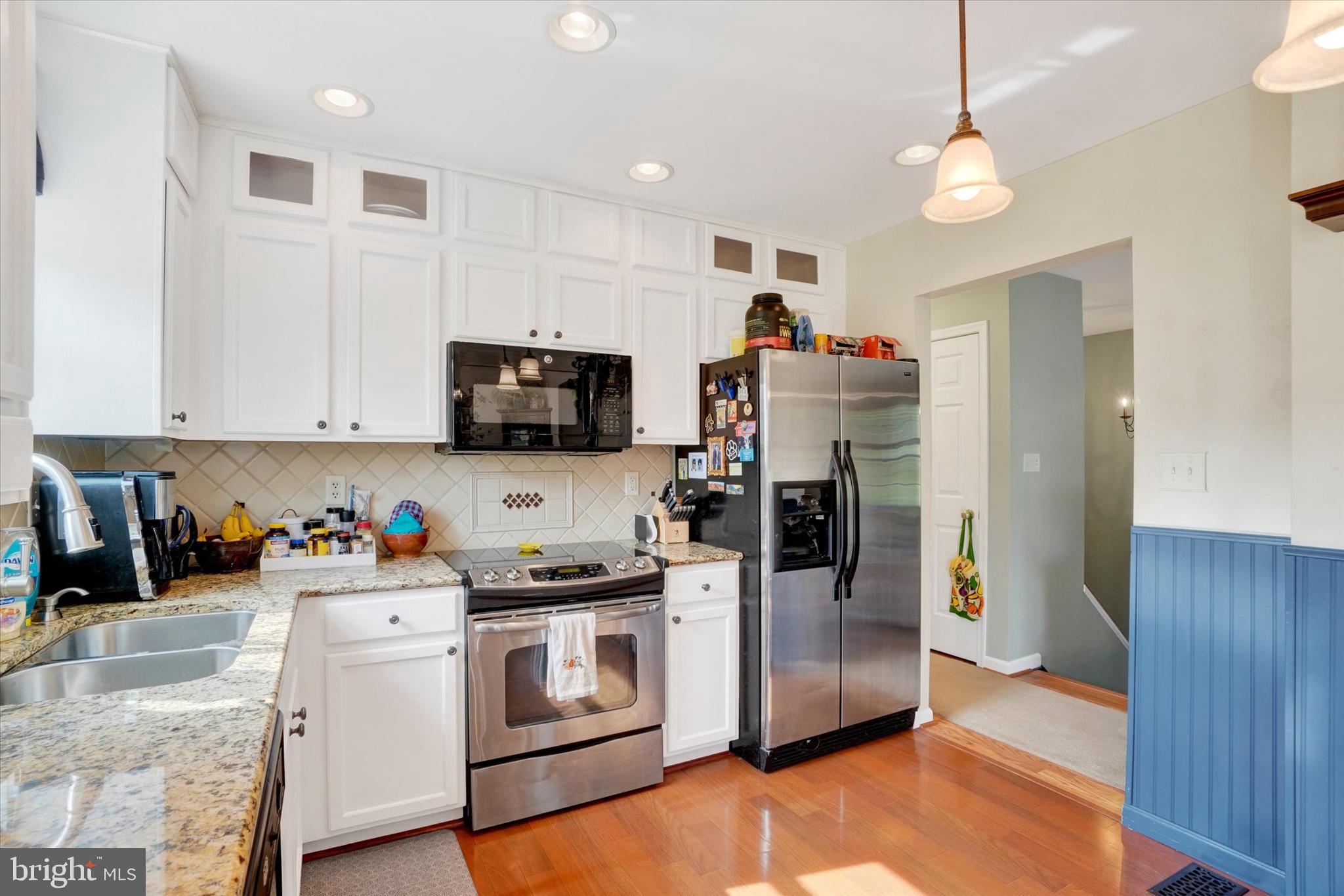 335 Sechrist Flat Road Felton, PA 17322 - Photo 9 of 28 a kitchen with stainless steel appliances white cabinets and wooden floor