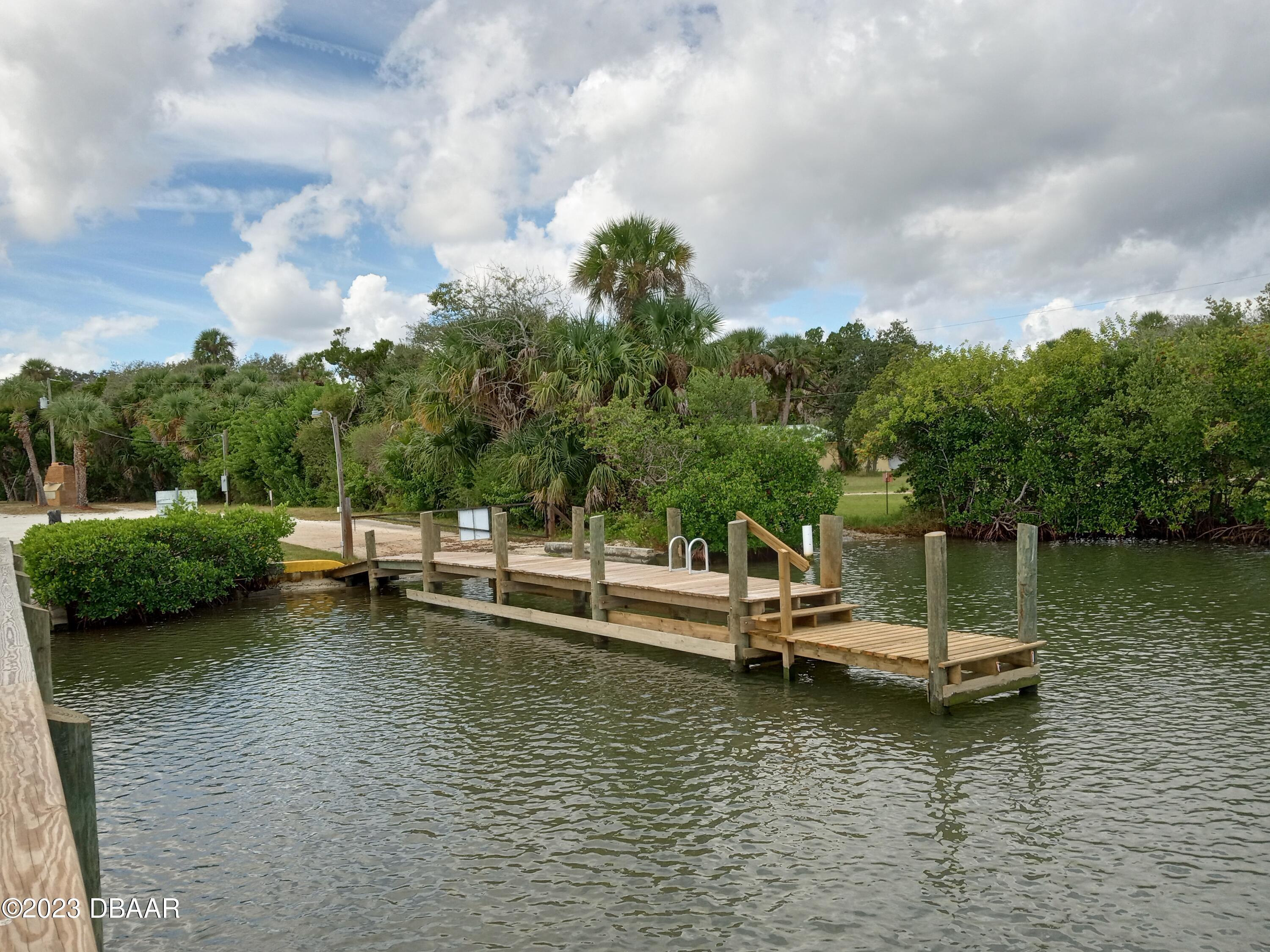4332 Cedar Way Edgewater, FL 32141 - Photo 12 of 25 a view of a lake with lawn chairs and a table