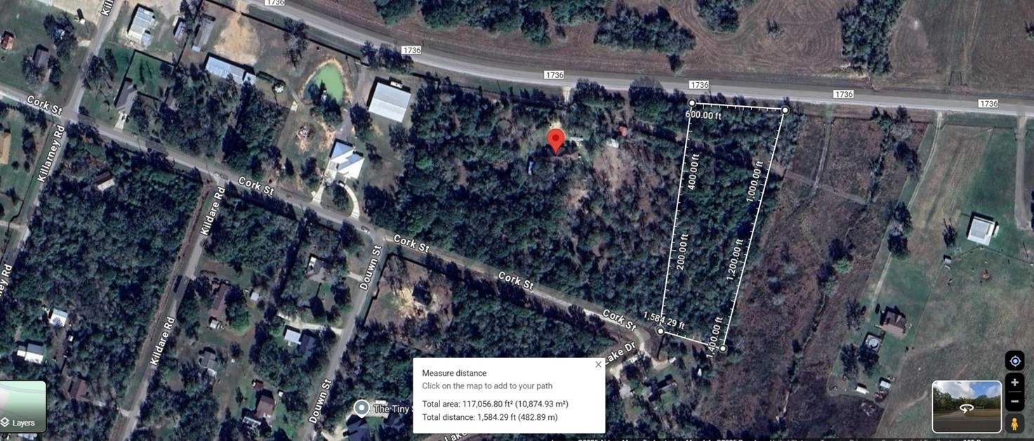 31365 B Fm 1736 Road Hempstead, TX 77445 - Photo 3 of 9 This aerial photo shows a plot of land outlined near Cork Street and FM 1736. The area is mostly wooded with nearby houses, indicating a residential neighborhood. The plot is rectangular and located close to main roads, offering convenient access.