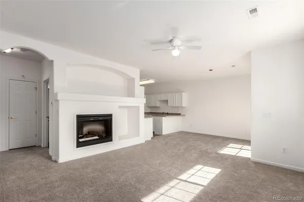 a view of empty room with fan and fireplace