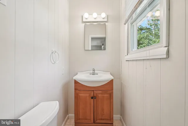 a bathroom with a toilet a sink and mirror