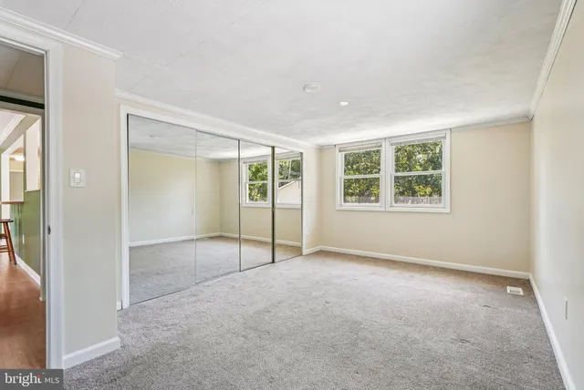 an empty room with windows and closet