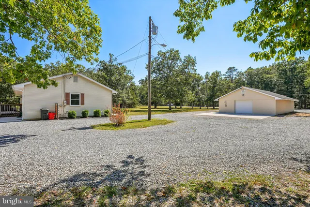 a view of a house with backyard and trees
