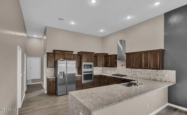a kitchen with stainless steel appliances granite countertop a refrigerator and a sink