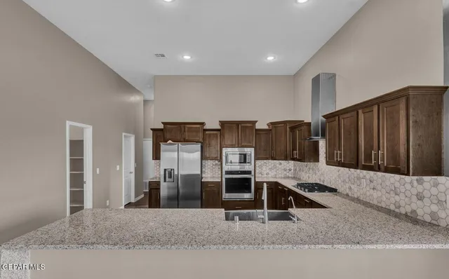 a kitchen with stainless steel appliances granite countertop wooden cabinets a sink and dishwasher