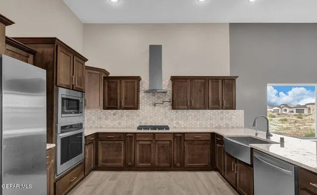 a kitchen with granite countertop a center island a sink cabinets and wooden floor