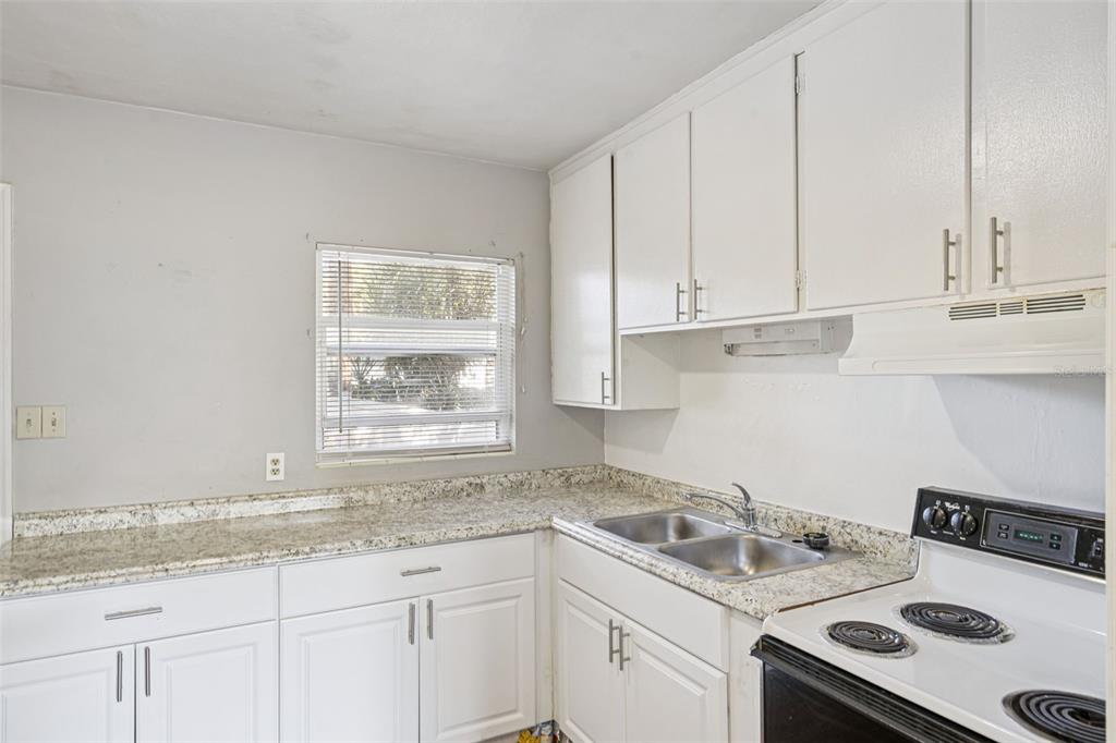 420 Euclid Avenue, Unit 1 Leesburg, FL 34748 - Photo 8 of 18 a kitchen with a sink stove and cabinets