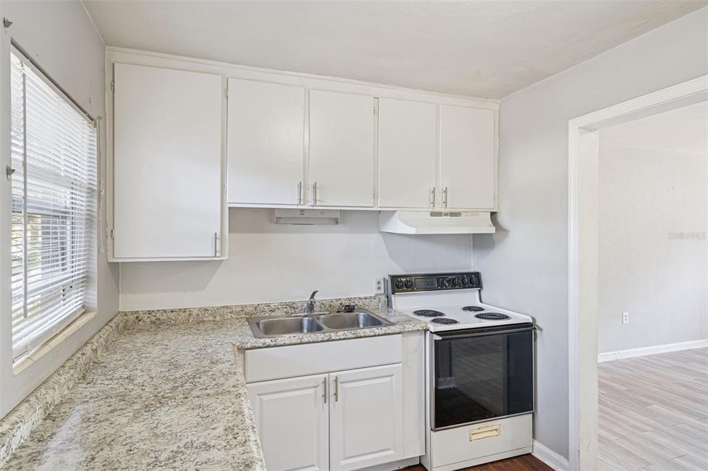 420 Euclid Avenue, Unit 1 Leesburg, FL 34748 - Photo 9 of 18 a kitchen with granite countertop white cabinets and white appliances