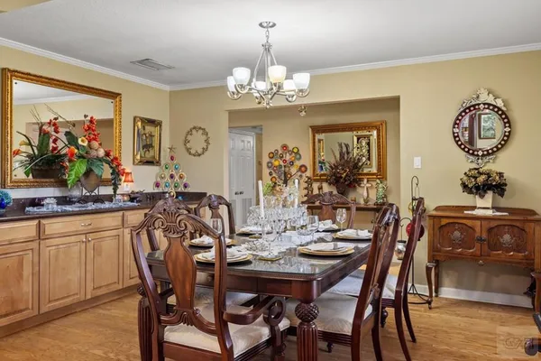 a view of a dining room with furniture a chandelier and wooden floor