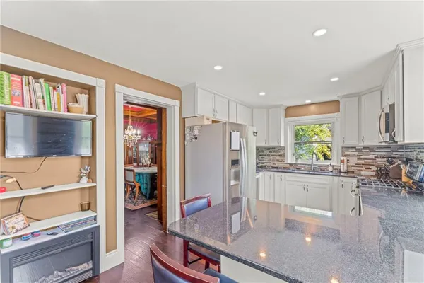 a kitchen with stainless steel appliances granite countertop a refrigerator and a stove top oven
