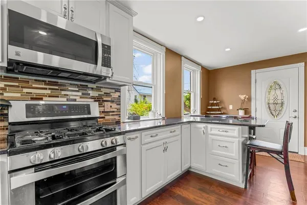 a kitchen with stainless steel appliances a stove sink and microwave