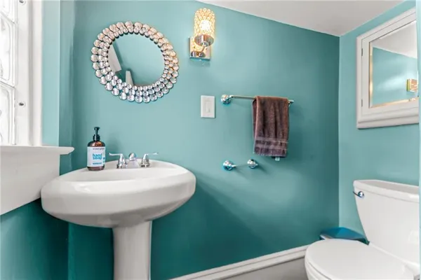 a bathroom with a toilet sink and mirror