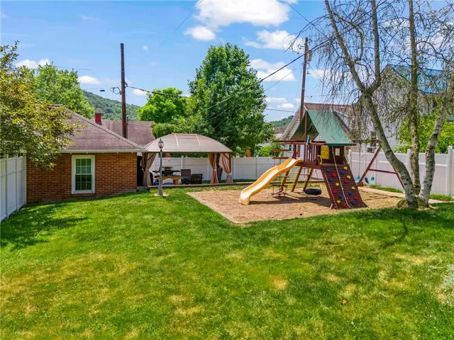 a view of a house with backyard and tree