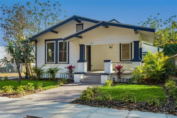 a front view of a house with a yard and potted plants