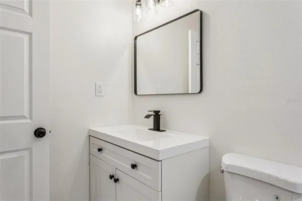 a bathroom with a toilet sink and mirror