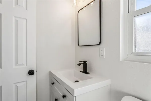 a bathroom with a toilet sink and mirror