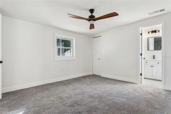a view of empty room with window and a ceiling fan