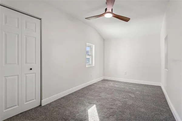 an empty room with a chandelier fan