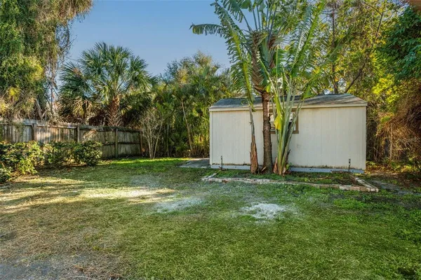 a view of a yard with a house and a large tree