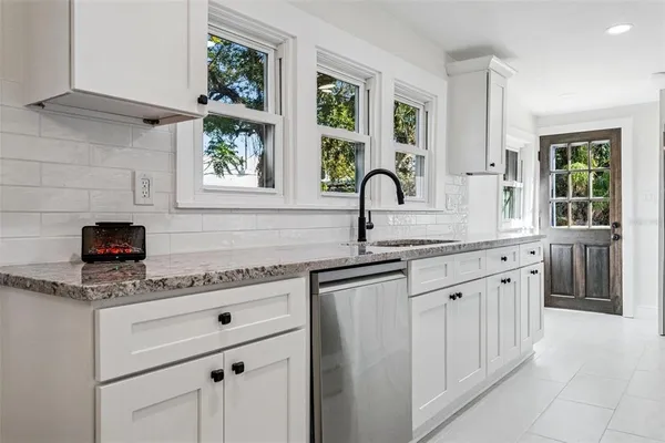 a kitchen with stainless steel appliances granite countertop a sink and a granite counter tops