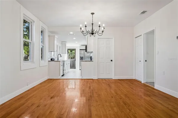 a view of a kitchen with wooden floor and a large window