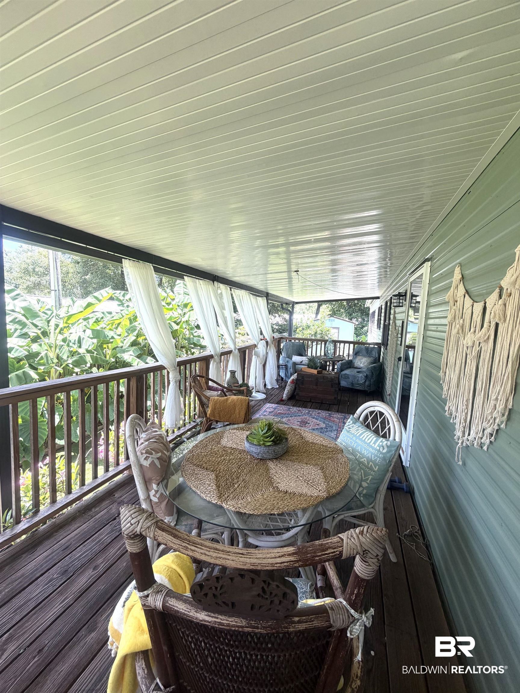 1620 Del Rey Drive Lillian, AL 36549 - Photo 4 of 45 Expansive covered porch featuring wood-finish flooring, a wood railing, and a slatted ceiling