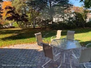 a view of a lake with table and chairs under an umbrella