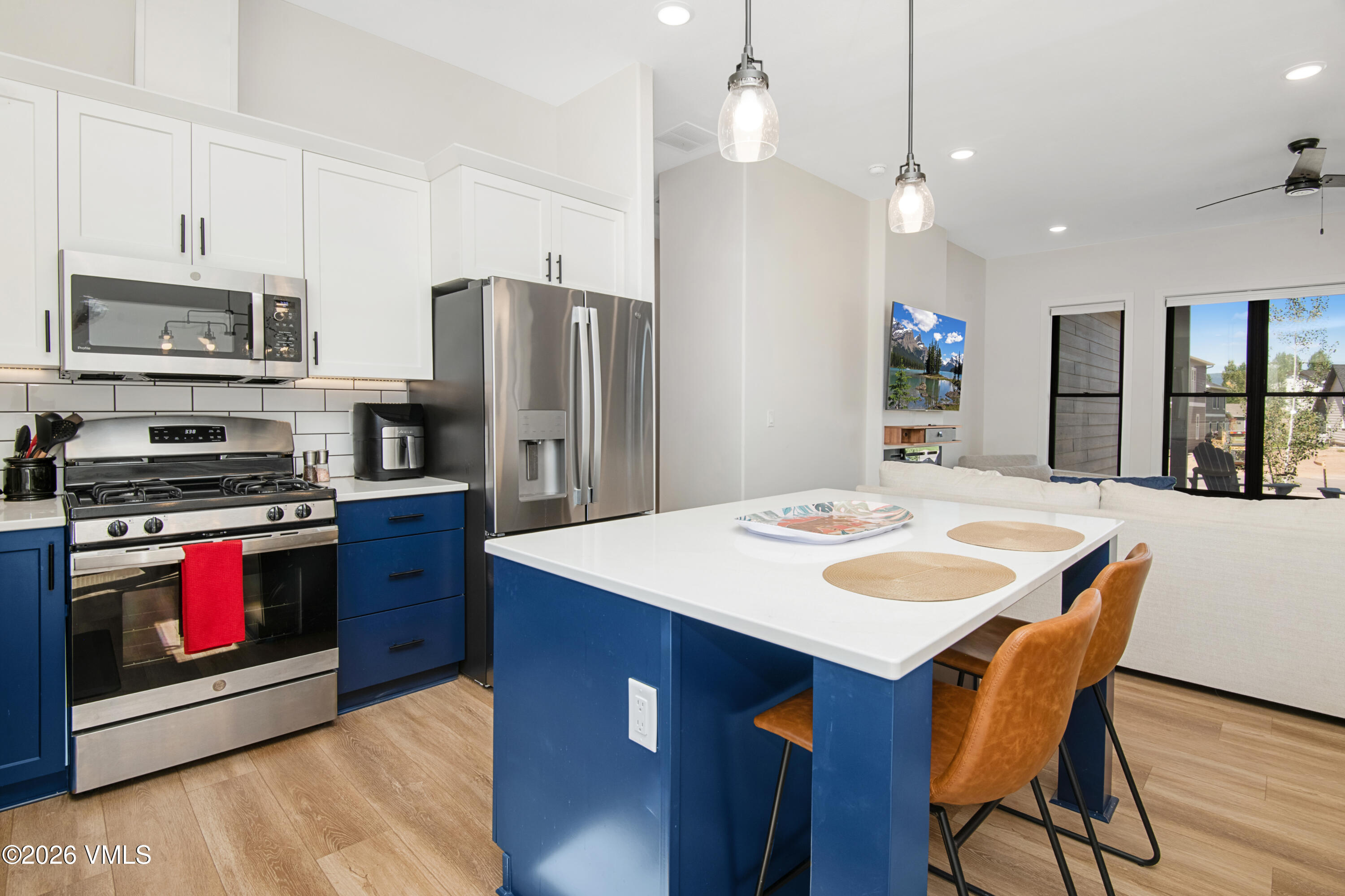 270 Blackhawk Road Gypsum, CO 81637 - Photo 6 of 27 a kitchen with stainless steel appliances granite countertop a stove a refrigerator a kitchen island a sink dishwasher and white cabinets with wooden floor