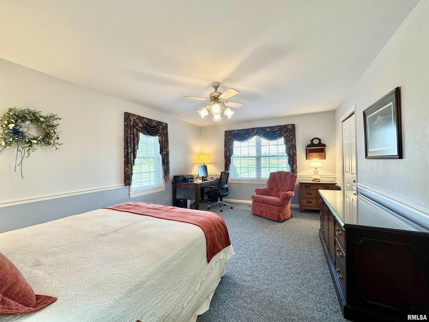 9879 Steel City Road Benton, IL 62812 - Photo 31 of 60 a spacious bedroom with a bed and a chandelier