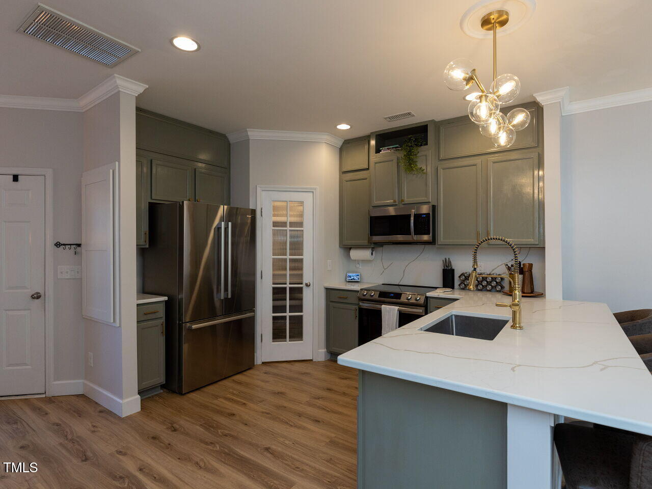 1117 Ileagnes Road Raleigh, NC 27603 - Photo 7 of 27 a kitchen with kitchen island a sink stainless steel appliances and refrigerator