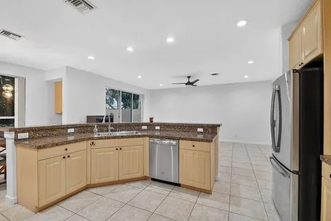 a kitchen with a refrigerator sink and cabinets