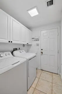 an empty room with wooden floor chandelier fan and windows