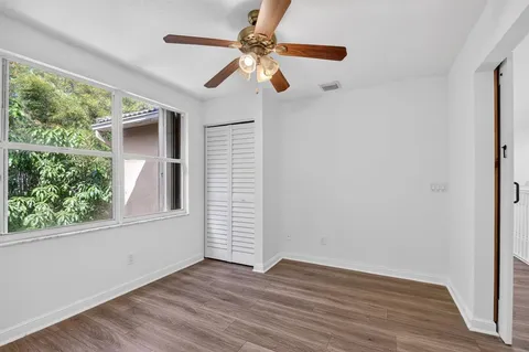 an empty room with a window and a fan