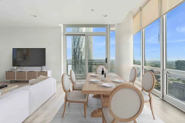 a dining room with furniture a flat screen tv and a large window