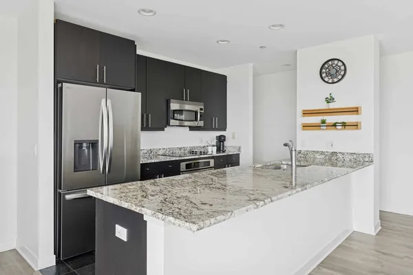 a kitchen with kitchen island a counter top space cabinets and stainless steel appliances