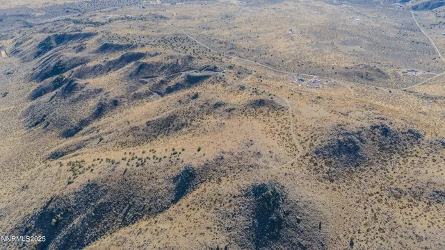 a view of a dry yard with mountains in the background