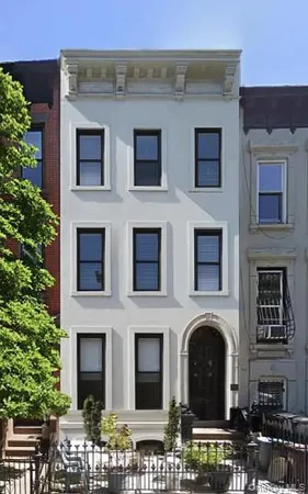 a front view of a building with plants