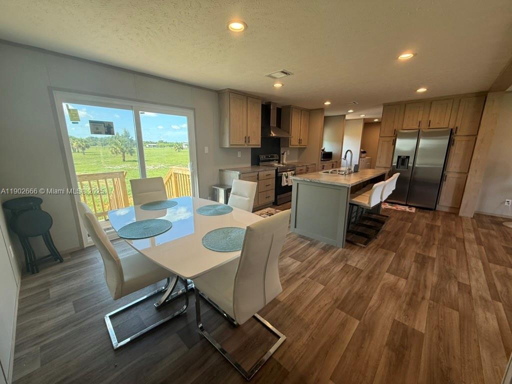 1250 Homestead Avenue Clewiston, FL 33440 - Photo 12 of 32 a view of a dining room with furniture window and wooden floor